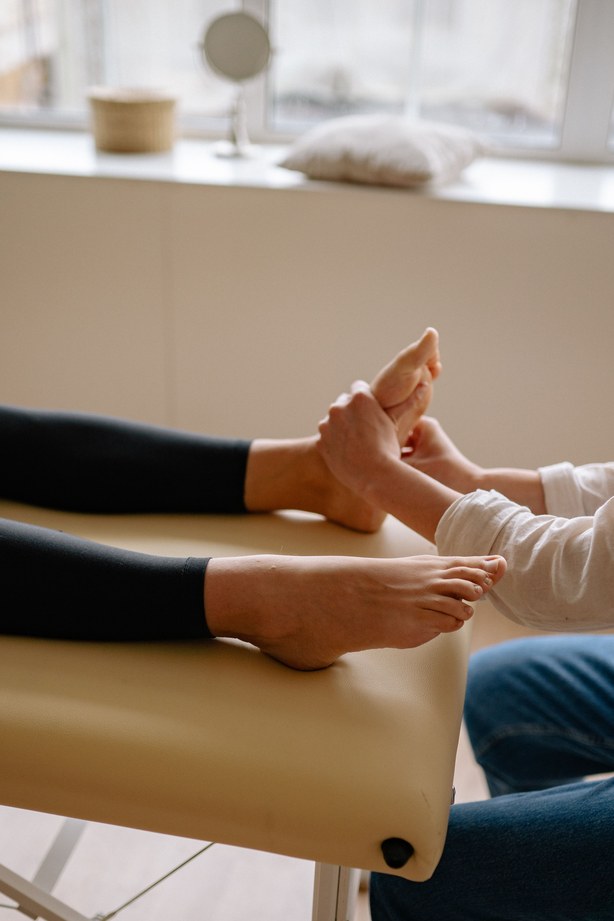 Fußmassage – Masseurin arbeitet an den Fußsohlen