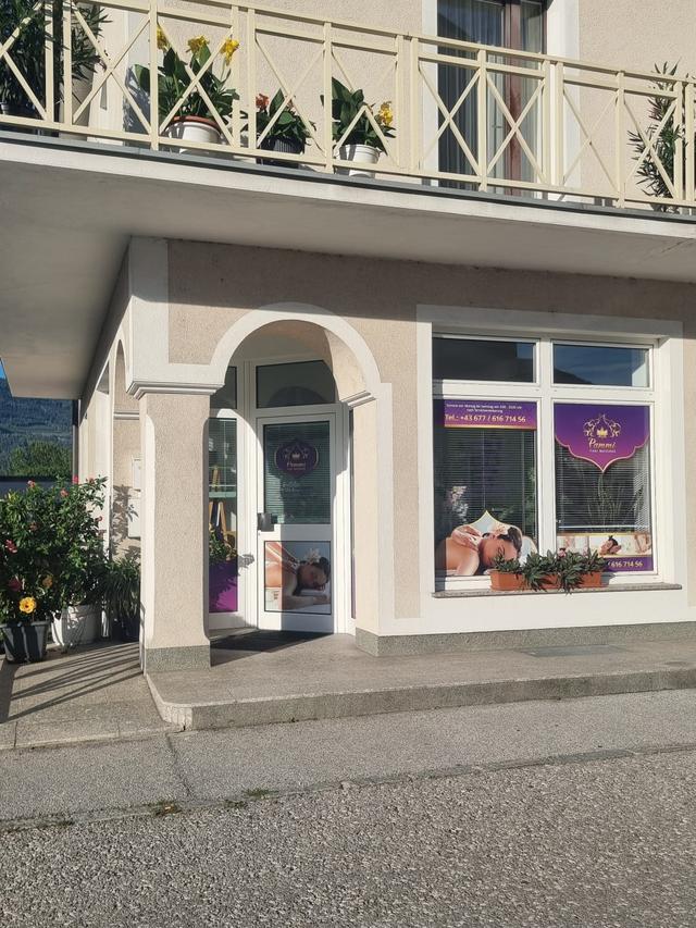 Das Studio von der Straße aus: Eingangstür mit Pammi-Logo und Schaufenster mit Massage-Motiven